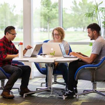 Diverse Workiva employees working around a table