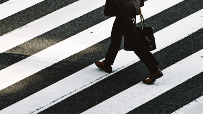 business person in a suit walking through a crosswalk